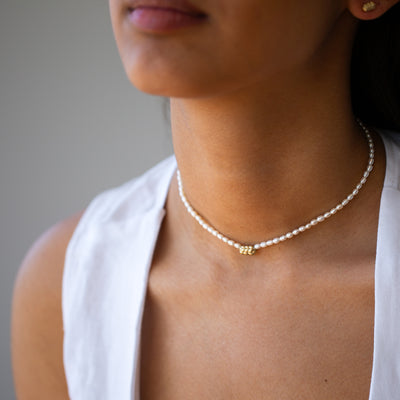 Women wearing challah necklace in 14k yellow gold,  with pearls chain