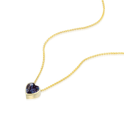 Yellow Gold Alexandrite necklace with a heart-shaped purple gemstone pendant on a white background