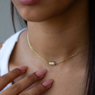 closeup of a women's neck wearing a 14K yellow Gold Challah Necklace, with an edgy chain