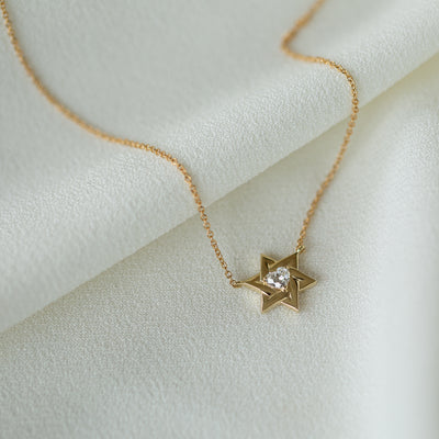 closeup of a 14K yellow gold Star Of David With a Diamond Heart Necklace