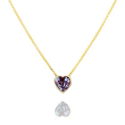 Gold necklace with a heart-shaped Alexandrite gemstone pendant on a white background