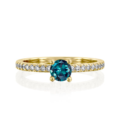 Gold ring with a green gemstone and smaller diamonds on a white background