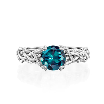 white gold alexandrite ring with a blue gemstone on a white background
