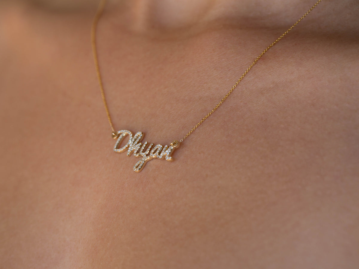 custom diamond name necklace in 14K yellow gold, worn on the body