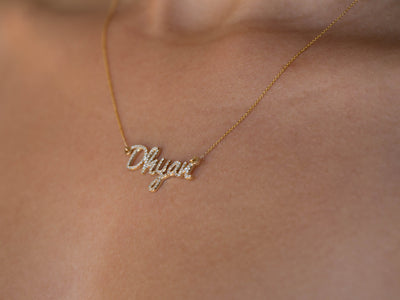 custom diamond name necklace in 14K yellow gold, worn on the body