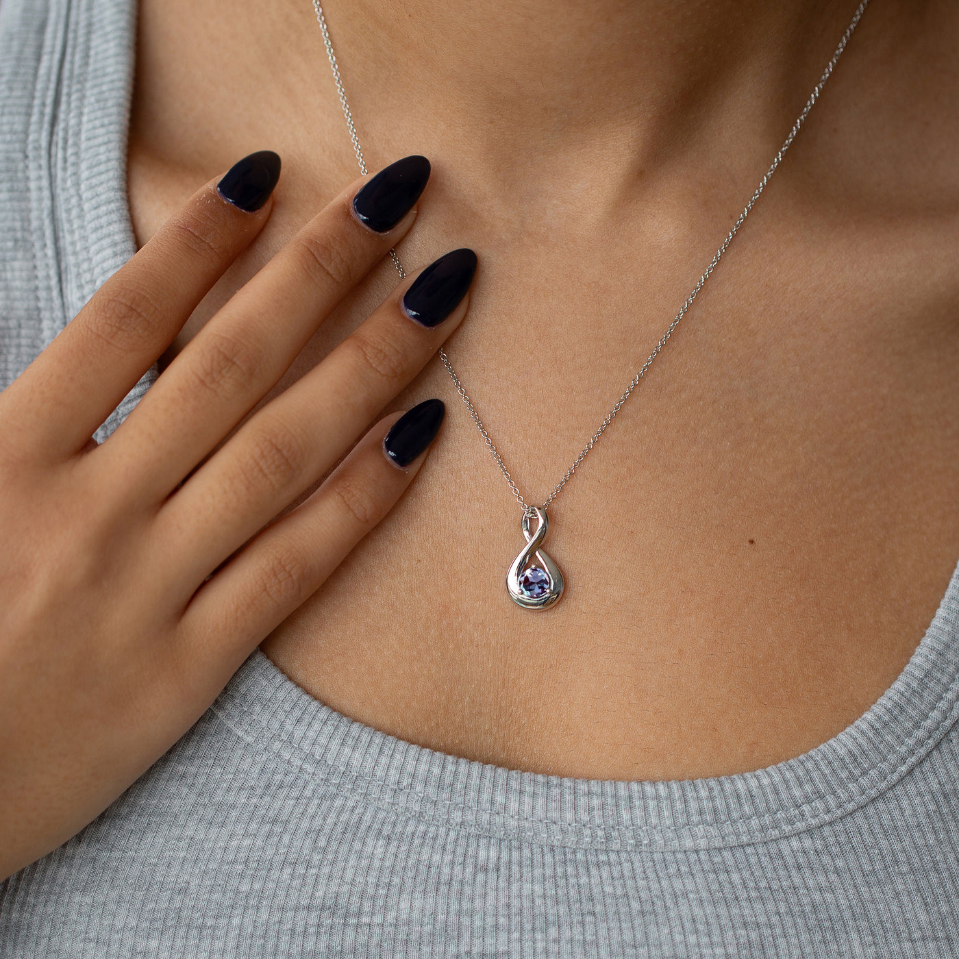 alexandrite necklace in an infinity design worn by a woman