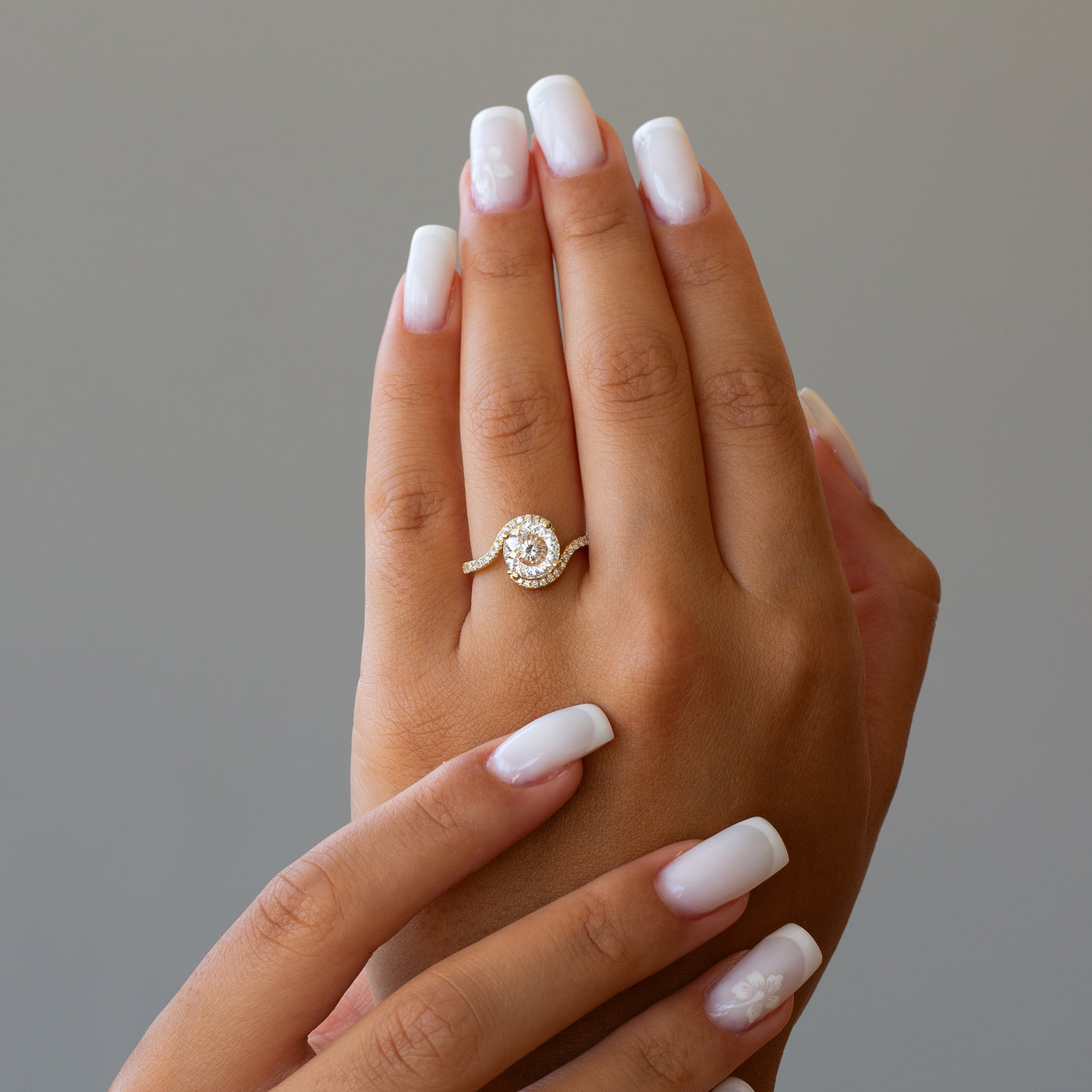 Hand wearing a moissanite ring 2 carat with a neutral background