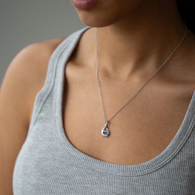 woman wearing a white gold infinity necklace set with alexandrite