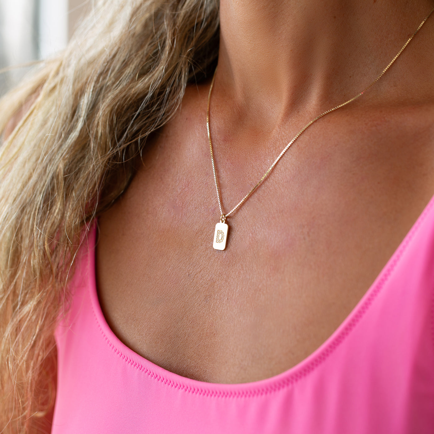 Custom diamond initial 14K yellow gold bar necklace worn on the body