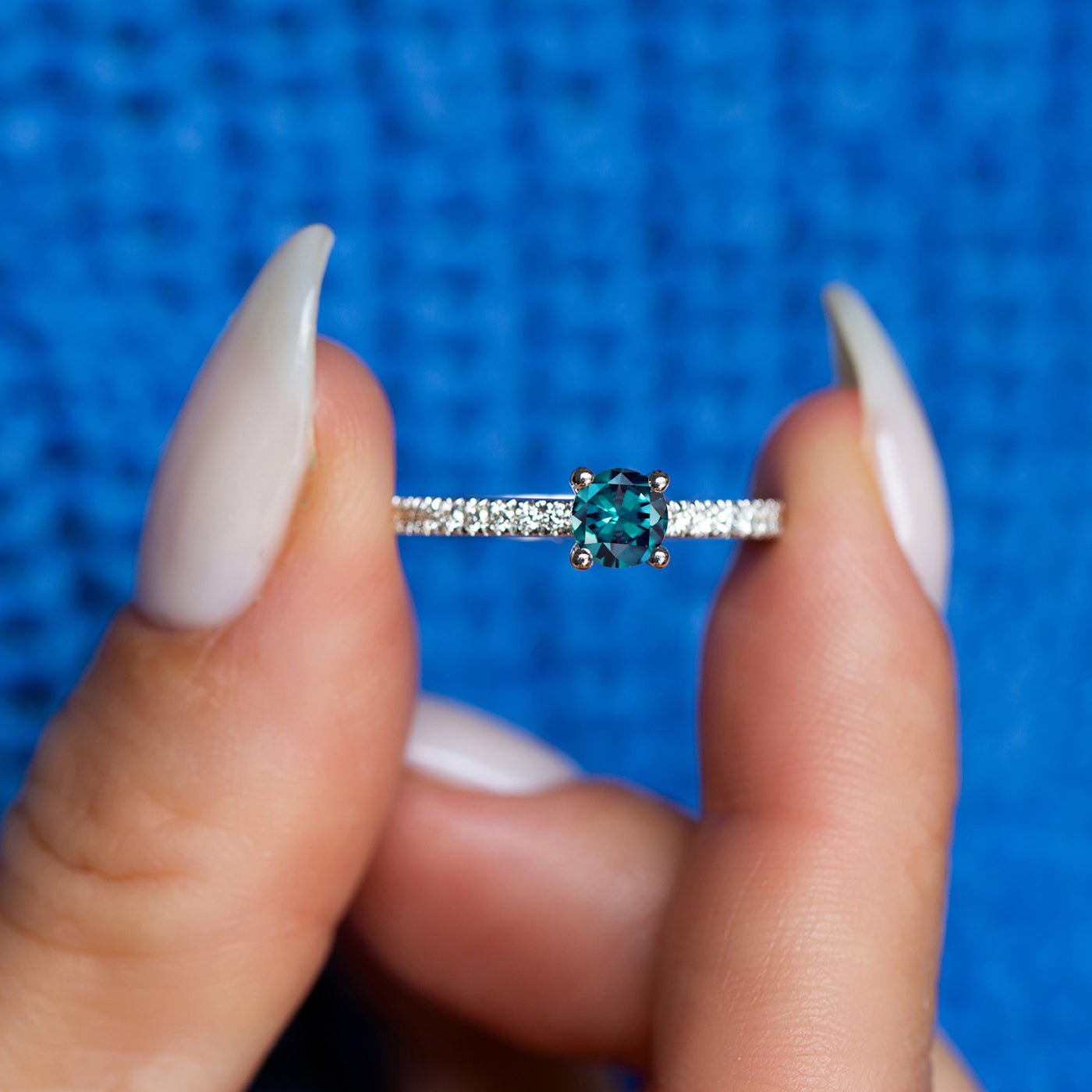 color changing engagement ring with diamonds on a blue background
