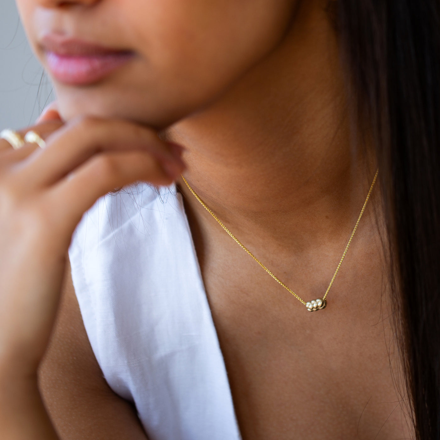 women wearing a 14K Gold knot Necklace, with a challah pendant and dainty chain