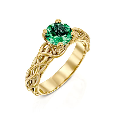 yellow gold emerald engagement ring on a white background