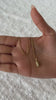 Women hand holding a 14K Gold Challah Necklace