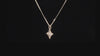 Video showing the sparkle of a gold star necklace set with diamonds on a black background