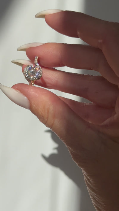 Hand holding a 2ct moissanite engagement ring in 14k gold