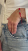 Video of a model's hand wearing a Kabbalah red string bracelet.