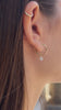 Video showcasing a model wearing diamond heart earrings, transitioning to a hand holding and displaying the piece.
