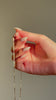 Video of a hand holding a marquise cut diamond necklace