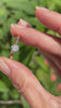 A video showcasing a minimalist engagement ring in 14K yellow gold worn on a hand, with another hand holding it to display the diamond's sparkle.