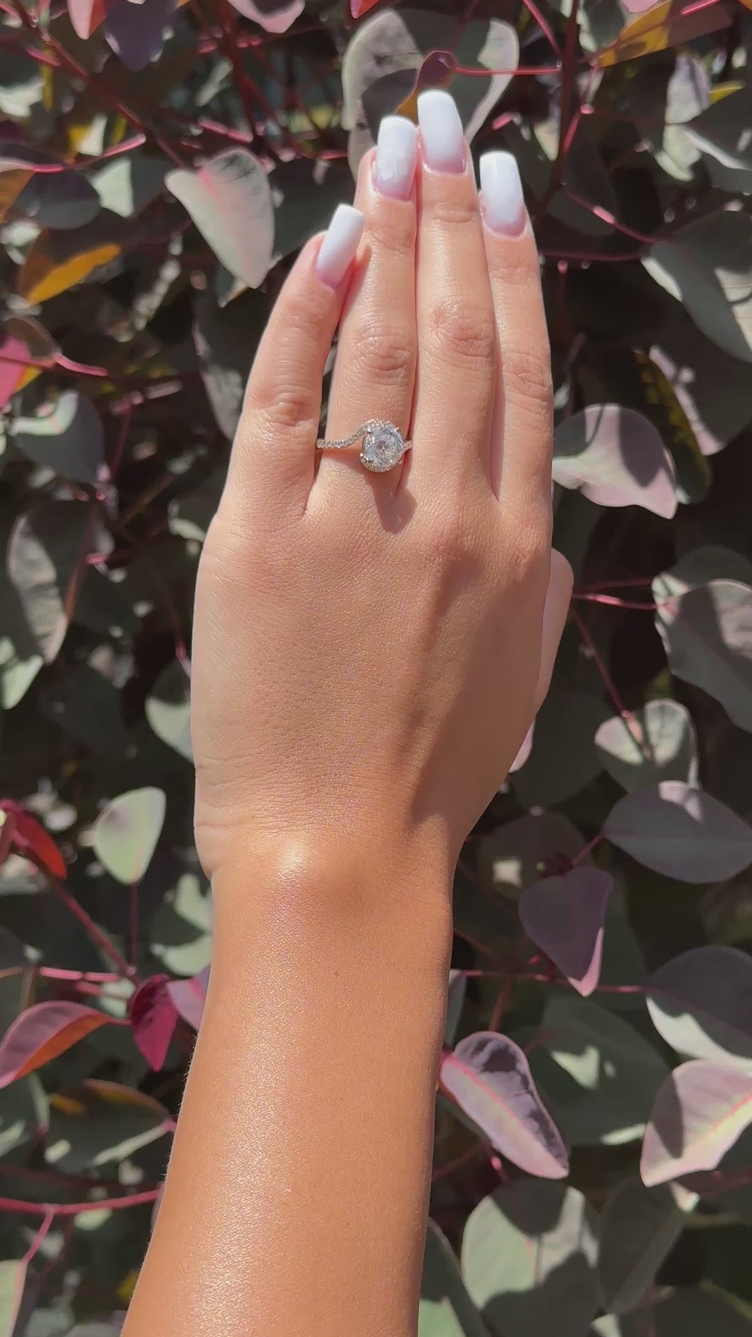 Hand wearing a twist halo moissanite ring with diamonds