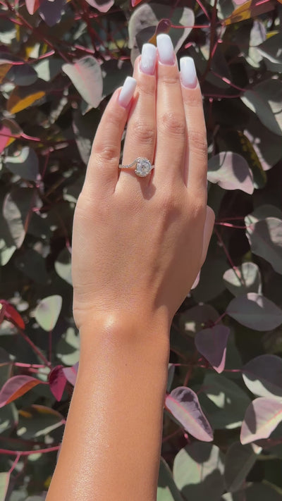 Hand wearing a twist halo moissanite ring with diamonds