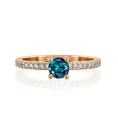 rose Gold ring with a teal gemstone on a white background