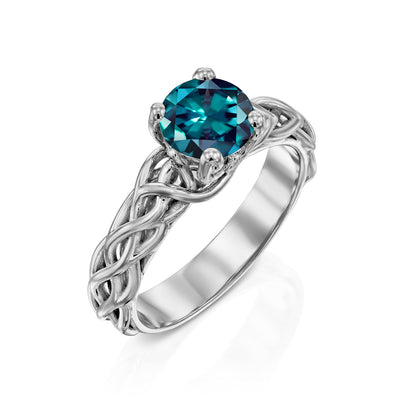 white gold ring with a teal gemstone on a white background