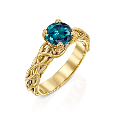 teal engagement ring in yellow gold on a white background