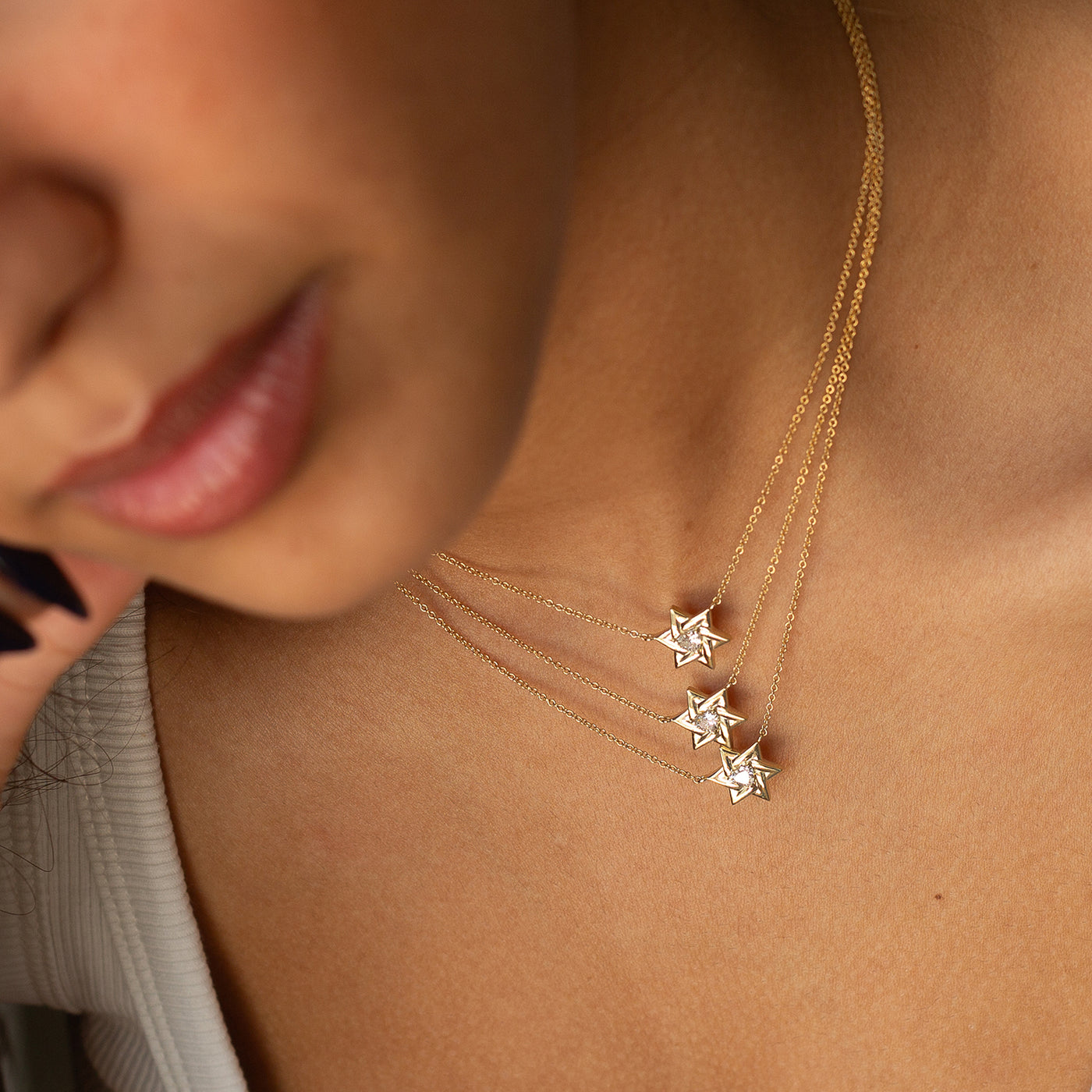 women wearing three layers of 14K Star Of David With a Diamond Heart Necklace